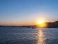 Calm sea and sunset in the cloudless orange evening sky