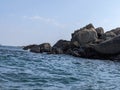 Calm sea surrounded by rocks and blue sky Royalty Free Stock Photo