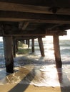 Calm sea waves under a wooden plank jetty in Seaford, VIC, Australia