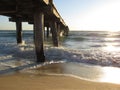 Calm sea waves under a wooden plank jetty in Seaford, VIC, Australia