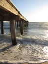 Calm sea waves under a wooden plank jetty in Seaford, VIC, Australia