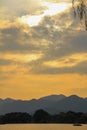 A calm seascape with mountains at sunset. Dramatic sky and cloudscape Royalty Free Stock Photo