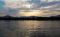 A calm seascape with mountains at sunset. Dramatic sky and cloudscape Royalty Free Stock Photo