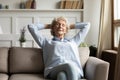 Calm senior woman relax on couch in living room