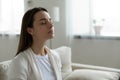 Calm woman resting closed eyes breathing fresh humidified air