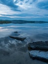 Calm, serenity, meditation concept. Sunset on the lake, stones in the water in the foreground, quiet water, cloudless sky