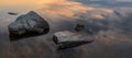 Calm, serenity, meditation concept. Sunset on the lake, stones in the water in the foreground, quiet water, cloudless sky