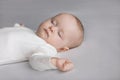 Calm silent adorable baby in white bodysuit sleeping on bed Royalty Free Stock Photo