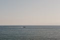 Calm sky and sea at sunset, unidentified speed boat in the distance Royalty Free Stock Photo