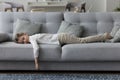 Calm sleepy little kid girl lying on belly on couch Royalty Free Stock Photo