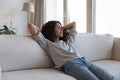 Calm sleepy pretty young Hispanic woman resting on soft couch