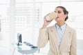 Calm smart brown haired businesswoman drinking coffee