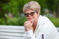 Calm and smiling European senior woman looking at camera outdoor. Copy space