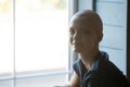 Calm smiling young woman receiving cancer treatment sitting by window