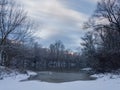 Calm snowy winter scene with river, snow covered riverbanks and naked trees Royalty Free Stock Photo