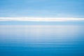 Calm and still open sea blurring into a blue sky Royalty Free Stock Photo