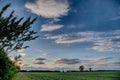 White fluffy clouds in the blue sky above the green field