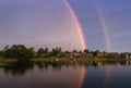 Calm summer landscape with double rainbow above the lake, blue sky and boats. Royalty Free Stock Photo