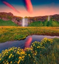 Calm summer sunrise on Seljalandsfoss - where tourists can walk behind the falling waters