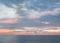 Calm sunset or sunrise over the Mediterranean sea, the sun shining through soft blue and pink clouds Royalty Free Stock Photo