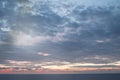 Calm sunset or sunrise over the Mediterranean sea, the sun shining through soft blue and pink clouds Royalty Free Stock Photo