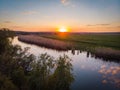 The calm surface of the river, orange sunset, green fields and meadows in a quiet warm summer evening Royalty Free Stock Photo