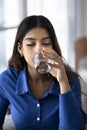 Calm thirsty young 20s Indian girl enjoying cold beverage