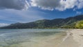 Calm turquoise ocean and sandy beach. Yachts in the distance. Royalty Free Stock Photo