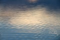 The calm water surface with reflections of different colors.