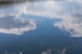 Calm water surface. Summer evening near a forest lake, the surface of the water is smooth, with small waves. The sky with clouds Royalty Free Stock Photo