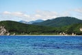 Calm waters of a bay. Rocky seashore of a Pacific Ocean. Saltwater inlet. Green hills by the sea. Rocks on the shallows. Royalty Free Stock Photo