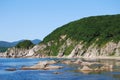 Calm waters of a bay. Rocky seashore of a Pacific Ocean. Saltwater inlet. Green hills by the sea. Rocks on the shallows. Royalty Free Stock Photo