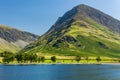 Calm waters of Buttermere with the tall mountain of Fleetwith Pike and the Honnister Pass behind (Lake District Royalty Free Stock Photo