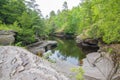 Calm waters on rocky forest shoreline of river in the Porcupine Mountains Wilderness State Park in the Upper Peninsula of Michigan Royalty Free Stock Photo