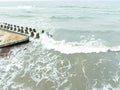 Calm waves roll towards resilient concrete structures along the coast The cloudy sky reflects a tranquil ambiance making