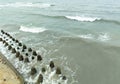 Calm waves roll towards resilient concrete structures along the coast The cloudy sky reflects a tranquil ambiance making