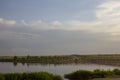 The calm wide river carries its waters under the morning sky