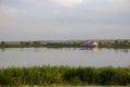 The calm wide river carries its waters under the morning sky