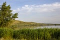 The calm wide river carries its waters under the morning sky