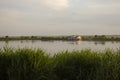 The calm wide river carries its waters under the morning sky