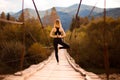 Calm woman doing yoga balance exercises. Yoga meditation on bridge over river with mountains background. Concept of Royalty Free Stock Photo