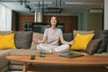 Calm woman meditate with mudra hands, practice yoga, control emotions, sitting on sofa at home. Stress free concept Royalty Free Stock Photo