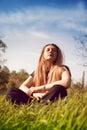 Calm woman relaxing in sunny grass field