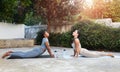 Calm young arab, african american women athletes in sportswear practice yoga, body stretching on mat