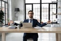 Calm businessman practice yoga at desk in office Royalty Free Stock Photo