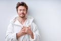 Calm young Caucasian male in bathrobe isolated on white studio background Royalty Free Stock Photo