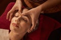 Relaxed Caucasian female client napping during facial acupressure