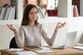 Peaceful girl distracted from studying meditating at workplace