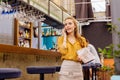 Calm young girl standing at the bar counter and talking on the phone Royalty Free Stock Photo