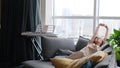 A calm young woman is resting on a couch with her eyes closed, her hands behind her head. A beautiful woman is Royalty Free Stock Photo